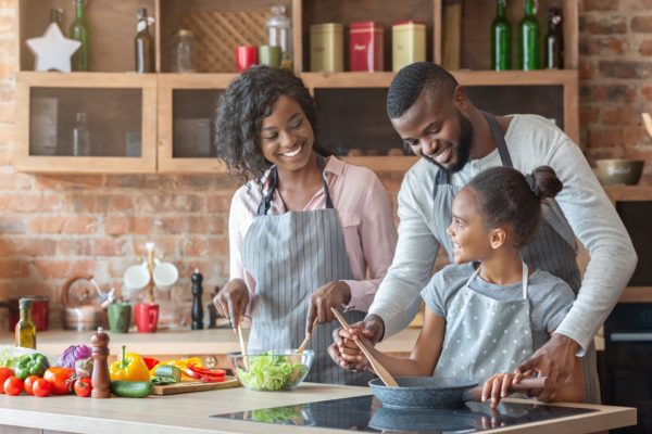 young parents teaching daughter how to cook QTLZGW8 600x400 - 7 Kid Friendly Activities You Can Do At Home